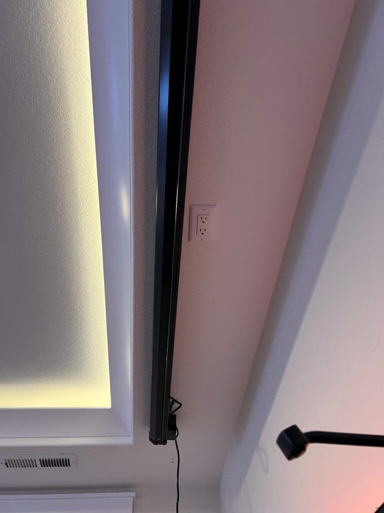 Ceiling-mounted light fixture with a power outlet on a textured ceiling.