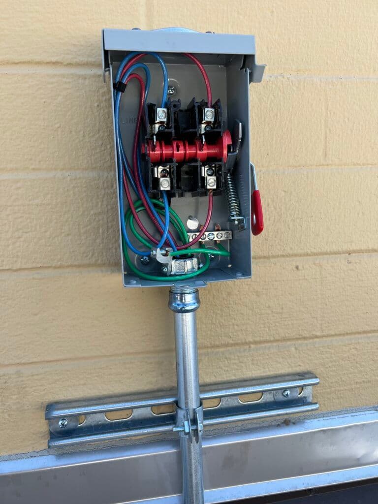 Electrical control box displaying wires, switches, and connections on a wall.