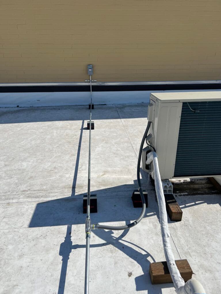 Roof-mounted air conditioning unit with insulation and electrical connections visible.